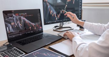Image of a man sitting at a desk trading on a PC platform.