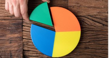 Image of a pie chart with a hand removing a piece, representing crypto portfolio management.